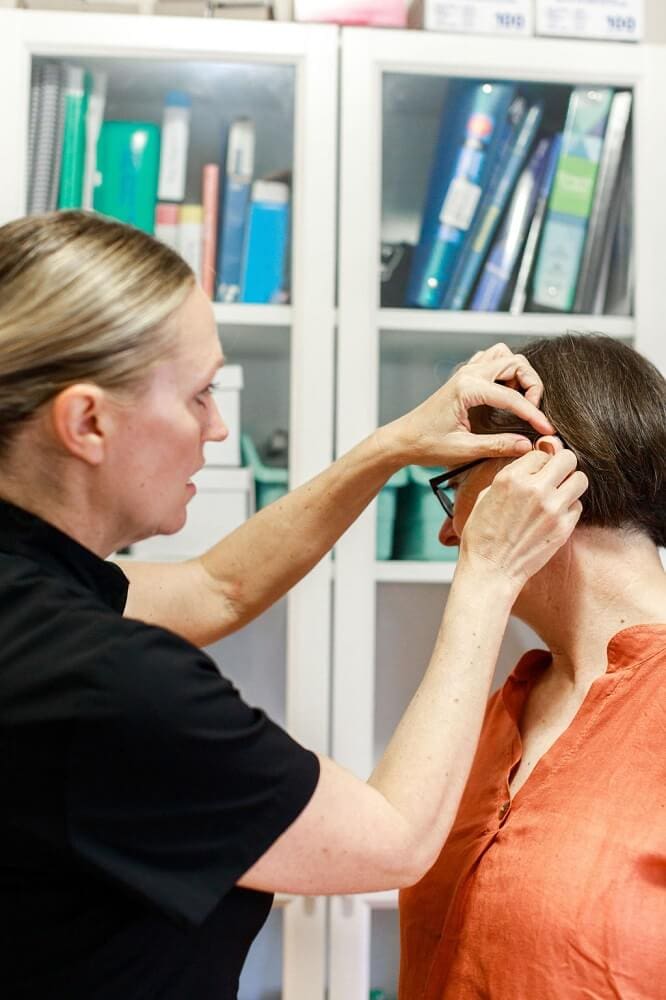 Jennifer Abbott of Hear At Home helping a patient with hearing aid fitting