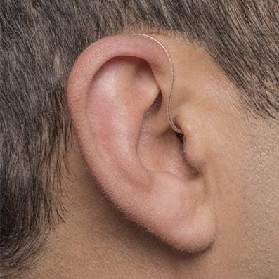 Mini Behind The Ear Hearing Aids. Showing a thin nearly invisible wire leaving the ear canal.